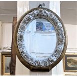 A 19th century oval porcelain framed mirror, the frame encrusted with flowers, within a gilt painted