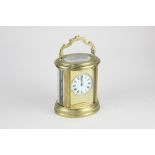 An oval brass and bevelled glass cased carriage clock, the movement stamped Paris, 18cm high