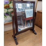 A mahogany framed toilet mirror, with rectangular bevelled mirror plate on down swept scroll feet,