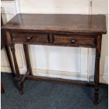 A small oak side table, with rectangular top above two drawers with turned knob handles, on turned