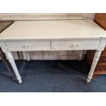 A white painted side table, with rectangular top above two drawers, on turned legs and ceramic