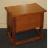 A 20th century oak box-stool, with hinged lid, on turned legs with low uniting stretcher, 48cm