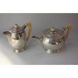 A George V silver teapot and matching hot water jug circular plain form, maker Alexander Clark,