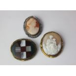 Two cameo brooches one of a mother and infant the other of a lady in profile and an oval agate and