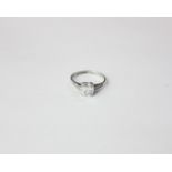 A diamond single stone ring the cushion cut stone four claw set and with four small stones to each