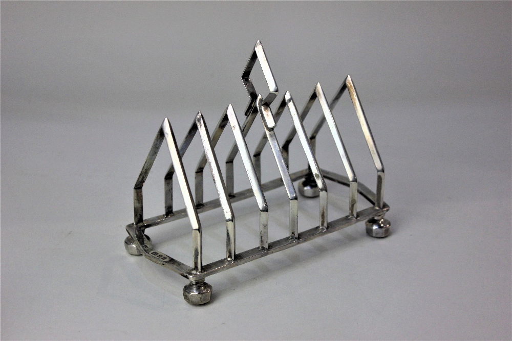 A George V silver toast rack six divisions with central handle, London 1910, 12oz 16cm