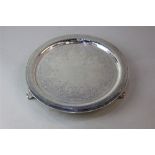 A Victorian silver circular tray with engraved decoration on three shell cast feet, maker Holland