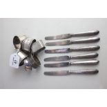 Six various silver napkin rings 4.6oz and a set of six George V silver handled dessert knives,