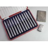 A cased set of twelve George V silver fruit knives Sheffield 1930, a rectangular cigarette case, 5.