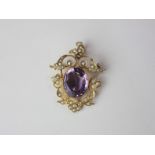 A late 19th early 20th century 9ct gold and amethyst pendant brooch with central oval amethyst and