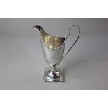 A George III silver cream jug, helmet form with beaded border on square pedestal base,maker John