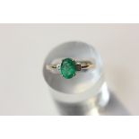 A Zambian pear cut emerald ring with diamond shoulders