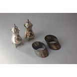 A pair of George V silver pepper pots baluster shape on four hoof feet, maker Elkington and Co.,
