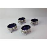 A set of four Edward VII silver salts, oval shape with pierced scroll sides on claw and ball feet,