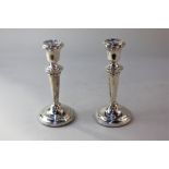 A pair of modern silver candlesticks with baluster stems and loaded circular bases, maker Poston