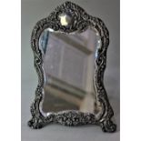 A Victorian silver mounted dressing table mirror embossed scroll shaped frame surmounted with vacant