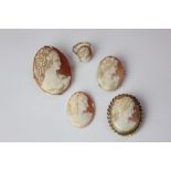 A shell cameo ring in 18ct gold; an unmounted oval shell cameo; and three gold mounted shell cameo