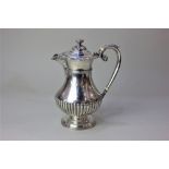 A Victorian silver hot water jug, baluster shape with reedied base, scroll handle and floral and