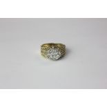An 18ct gold and diamond pave set dress ring with chain banded shoulders