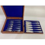 A set of six pairs of silver plated fish knives and forks with engraved blades in fitted case by