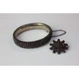 A garnet bangle, hinged, in silver, and a similar brooch