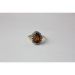 A citrine and diamond dress ring the oval cut stone multi claw set in a tiny diamond border in