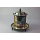 A silver plated biscuit barrel with domed lid and finial on circular base with gadrooned borders,