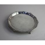 An Edward VII silver circular card dish with raised shell and bead border on three claw and ball