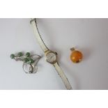 A small lady's 9ct gold Smiths wristwatch on leather strap, a green hardstone brooch, and an amber