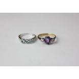An aquamarine three stone ring with tiny diamond whoulders in white gold; an amethyst ring with