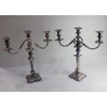 A pair of silver plated three-light candelabra with urn shaped sconces and detachable drip trays