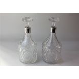 A pair of George V silver mounted cut glass decanters cylindrical shape with tapered necks and