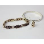 A 9ct gold garnet bracelet a silver clasp bracelet and a bracelet charm in the form of a miniature