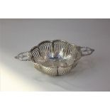 A George V pierced silver two-handled dish circular lobed form with floral cast handles and