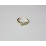 An 18ct gold diamond ring, with rubover set central diamond, shoulders with six small diamonds