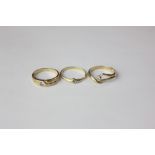 Three small diamond single stone rings variously mounted in yellow gold