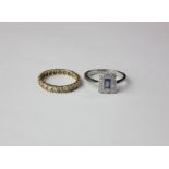 A sapphire and diamond ring with a central sapphire within millegrain set round diamonds in 18ct