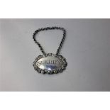 A George III silver sherry decanter label oval shape with shell and scroll border, maker John