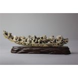 A Japanese carved ivory okimono group of figures in a boat on wooden stand, 22cm