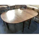 A mahogany drop leaf dining table with oval top on six tapered legs with pad feet, opens to 156cm