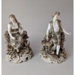 A pair of Rudolstadt Volkstedt porcelain figures of a seated man and women, on scroll bases, with