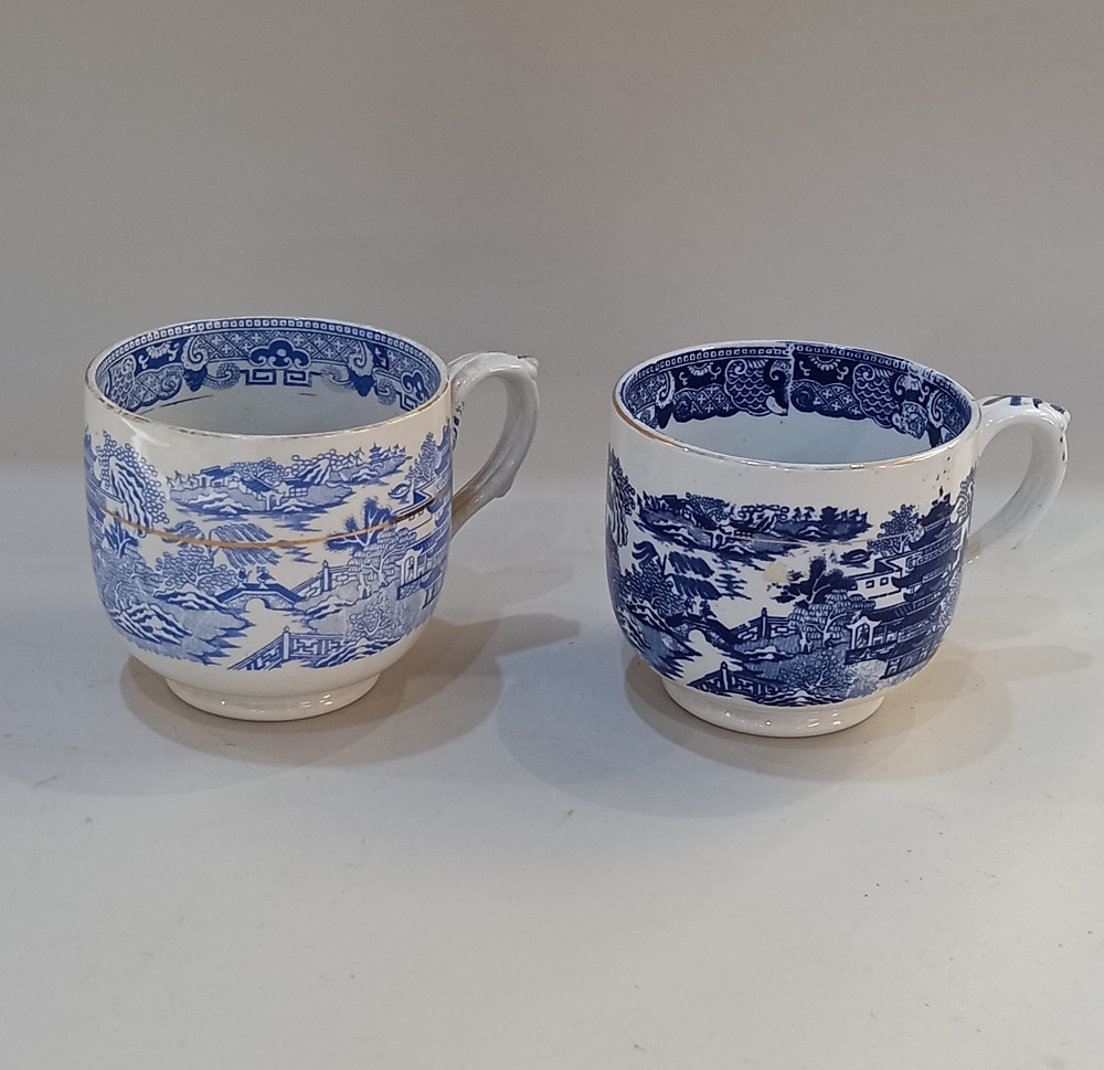 Two similar large blue and white cups with transfer printed Willow pattern style decoration, with