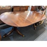 A reproduction Regency style mahogany extending dining table, with two additional leaves, on two