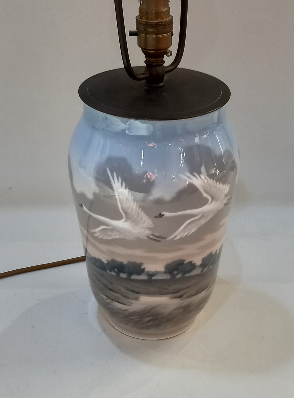 A Royal Copenhagen porcelain table lamp decorated with flying swans, 25.5cm high