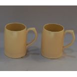 A pair of Keith Murray for Wedgwood yellow glazed pottery mugs printed and impressed marks to