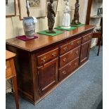 A George III oak dresser, with rectangular top above an arrangement of five drawers and two