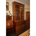 A Victorian style bookcase, possibly a marriage, with two glazed panel doors enclosing four