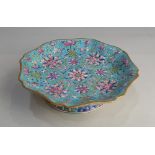 A Chinese turquoise ground famille rose porcelain footed dish, the shallow shaped bowl enamelled
