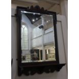 A late 19th / early 20th century mahogany framed wall mirror with bevelled glass above a rectangular
