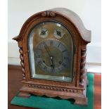 An early 20th century oak mantle clock with brass dial and silvered chapter ring, gong striking
